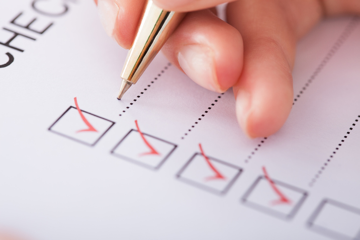Cropped image of businesswoman writing on checklist