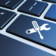 Computer service and assistance concept with work tool icon on a laptop keyboard 3D illustration.